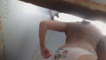 Lovely busty brunette woman in the beach cabin filmed on hidden cam