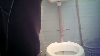 Pale skin white stranger girl in blue jeans pisses in the toilet