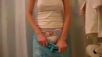 Nice girl stripping off her pyjama pants and showing nappy