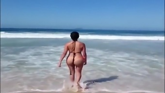 Large-assed harlot wears a flimsy bikini to the beach