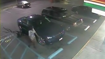 Desperate black woman soaks the parking lot next to the car
