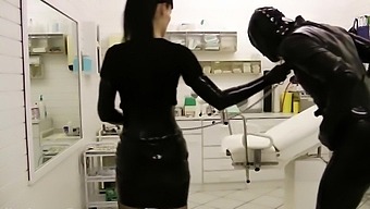 Perverted mistress is playing with tied-up gimp's cock and balls